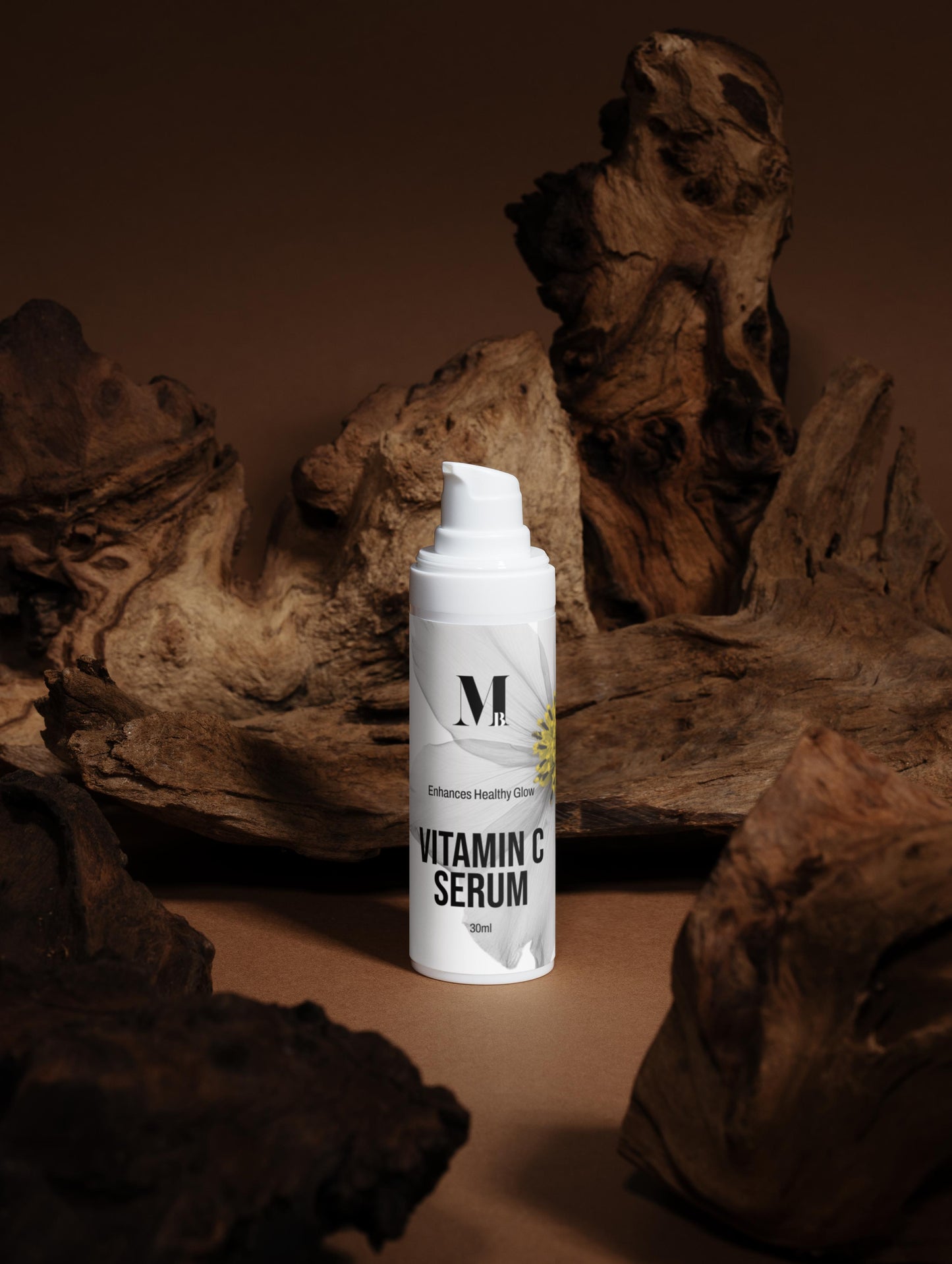 White serum bottle with a logo on a brown textured background