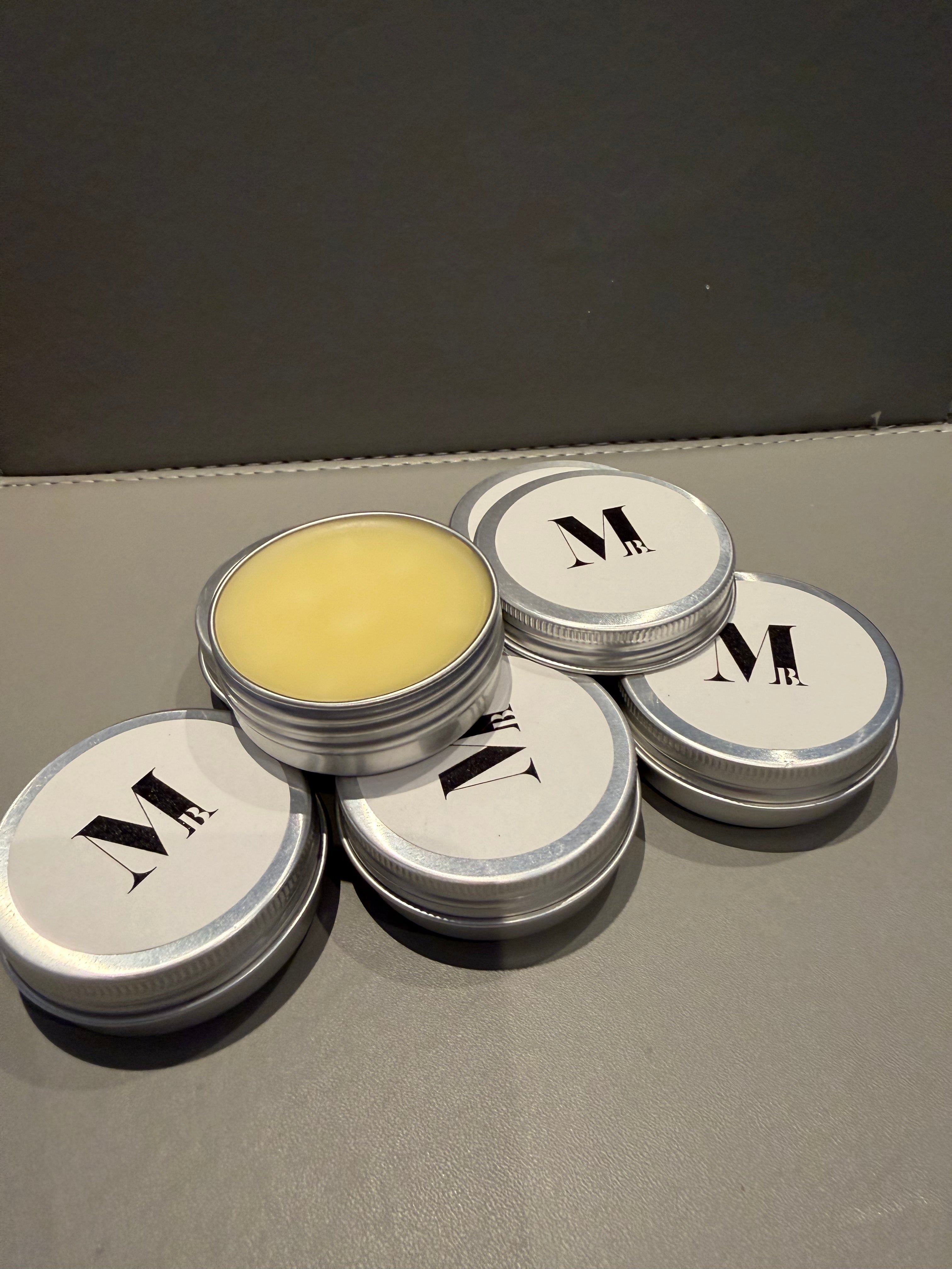Small containers with a yellow substance on a gray surface